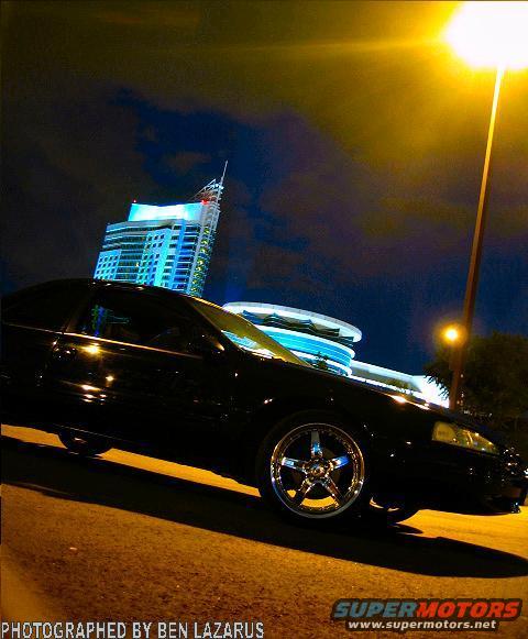 Black 1997 Ford Thunderbird 3q-front view with chrome wheels at night