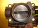 1993 Mazda MX-3 - Close-up of a throttle body, showing internal components and mounting holes.