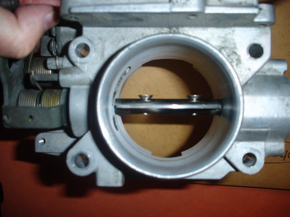 Throttle body with butterfly valve and screws visible inside the bore