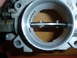 1993 Mazda MX-3 - Throttle body interior showing the butterfly valve and mounting screws.