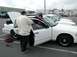 1998 Ford Crown Victoria - Two men are working on a white 1998 Ford Crown Victoria in a parking lot.