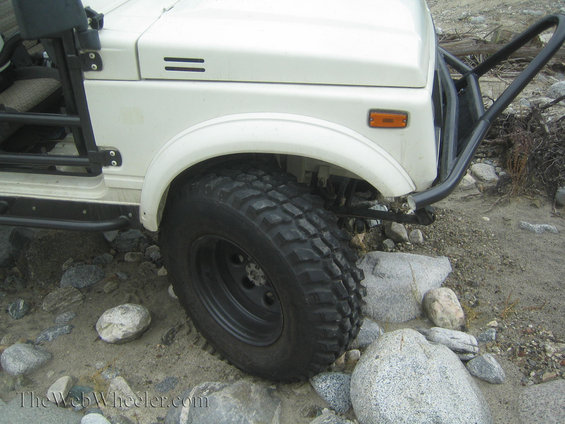 White 1987 Suzuki Samurai front fender, tire, and aftermarket bumper off-road
