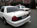 1998 Ford Crown Victoria - Two white police cars are parked in a lot. The foreground car is a 1998 Ford Crown Victoria.