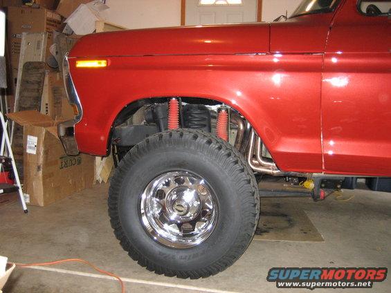 Red 1978 Ford Bronco front fender, wheel, and suspension components visible