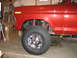1979 Ford Bronco - Close-up of a red 1978 Ford Bronco's front fender, wheel, and suspension.