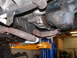 1994 Jeep YJ - The underside of a vehicle is viewed from below, revealing engine components and exhaust system.