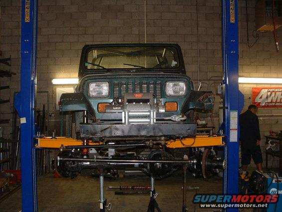 Green Jeep Wrangler front view on lift with winch