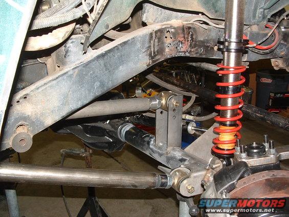 close-up of modified suspension on a vehicle, showing shocks, springs, and linkages