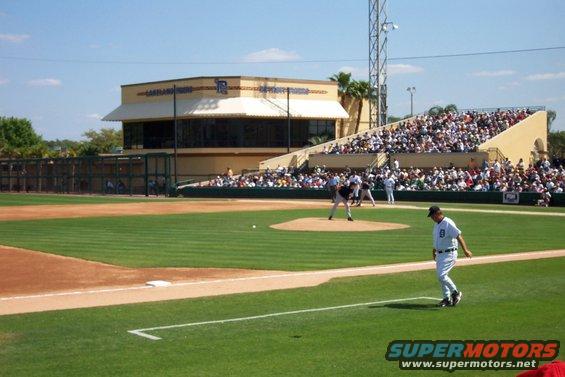 Baseball game in progress with players on the field and spectators in the stands