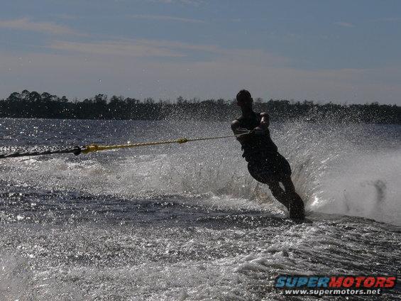 Waterskier cutting through spray, SUPERMOTORS logo visible