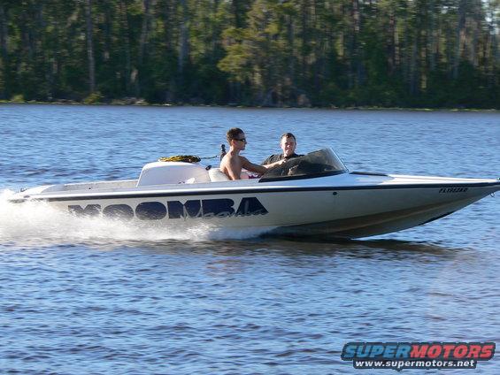 White speedboat with MOOMBA lettering on the side, two men onboard