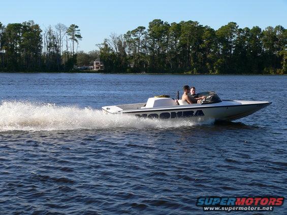 White speedboat with 'MOOMBA' text on its side, moving through water