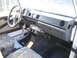 1987 Suzuki Samurai - The interior of a Suzuki Samurai features camouflage seat covers and a basic dashboard layout.