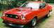 1975 Ford Mustang II - Red 1975 Ford Mustang II coupe with a black hood scoop and front air dam.