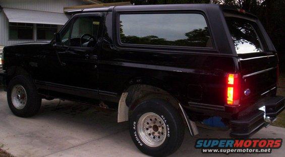 Black 1992 Ford Bronco parked on a driveway, viewed from the rear quarter angle