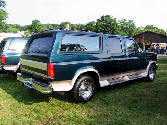 Green Ford Bronco Centurion Conversion with tan lower trim, viewed from the rear three-quarter angle
