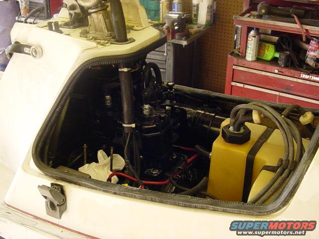 Boat engine compartment with yellow fluid reservoir and black engine components