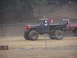 1995 Ford Bronco - Modified pickup truck with large tires and a driver in a helmet at an off-road park.