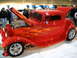 1993 Ford Taurus - A custom red hot rod with flame graphics is displayed with its hood and trunk open.