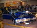1993 Ford Taurus - A classic blue sedan with its hood open, displaying its engine at a car show.