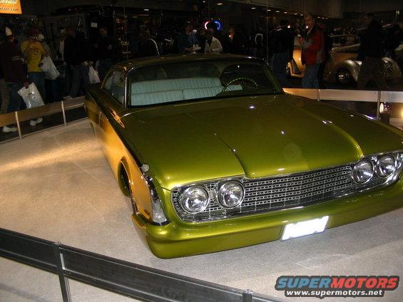 Lime green custom car with chrome grille and dual headlights. Interior is light blue
