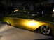 1993 Ford Taurus - A heavily modified classic car with a two-tone paint job and custom wheels is displayed indoors.