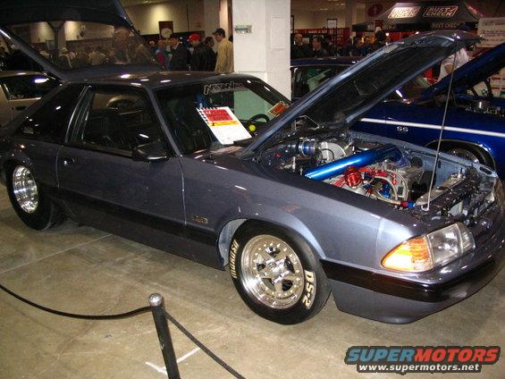 Gray coupe with hood open, showing custom engine and drag racing tires. Registry claims 1993 Ford Taurus