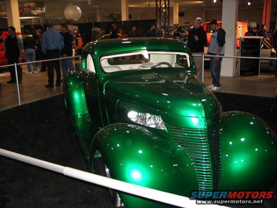 Green custom hot rod with a prominent grille and rounded fenders