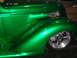 1993 Ford Taurus - Close-up of a custom green hot rod's fender and wheel, its metallic paint and chrome accents.