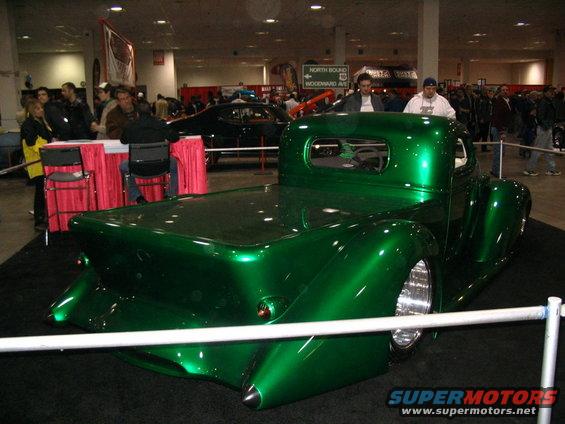 Green custom hot rod pickup truck with a chopped roof and custom rear fenders