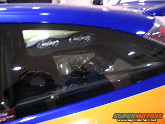 Blue and orange car side window with two circular emblems inside