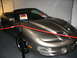 1993 Ford Taurus - A brown convertible Pontiac Firebird Trans Am is displayed indoors with a red rope barrier.