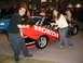 1993 Ford Taurus - Two people pose with a Honda race car at an indoor event.