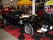 1993 Ford Taurus - A black Chevrolet Corvette is showcased indoors, with a red van visible in the background.