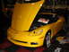 1993 Ford Taurus - A yellow Chevrolet Corvette is on display with its hood open, revealing the engine compartment.