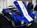 1993 Ford Taurus - A blue convertible with white racing stripes is displayed with its hood open, revealing the engine.