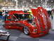 1993 Ford Taurus - Customized red pickup truck displayed indoors with flames painted on the body and hood.