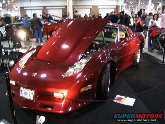 Red sports car with hood open, showing engine. License plate AIZK-911. Visible interior