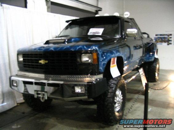 Blue pickup truck with flame graphics and custom bumper
