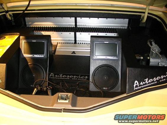Car trunk with two speakers, screens, JL Audio amplifier, and Autsonics car audio equipment