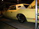 1993 Ford Taurus - Customized yellow coupe with vinyl top and large chrome wheels sits on display.