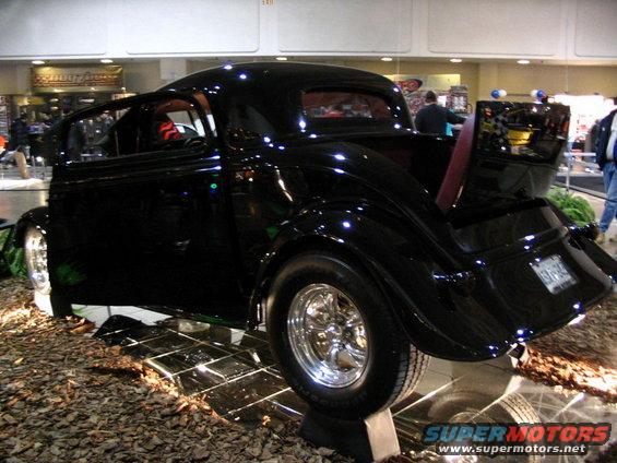 Black hot rod coupe with chrome wheels and open door