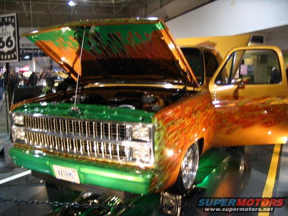 Green and orange flame-painted pickup truck with hood and door open