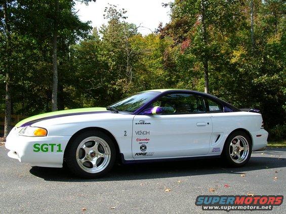 White 1995 Ford Mustang side view with green stripe and purple trim