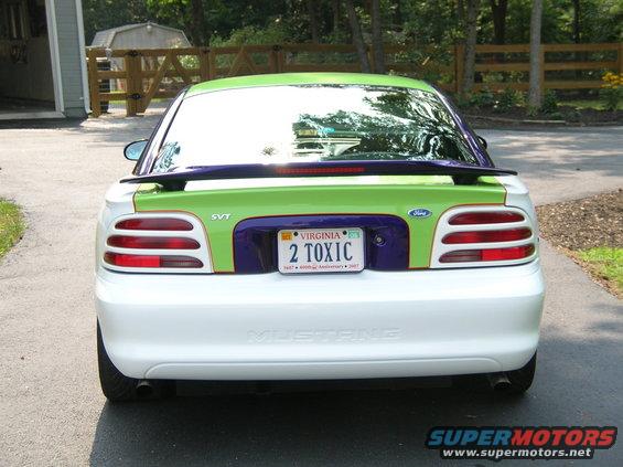 White Ford Mustang with green and purple accents on the rear, custom paint job