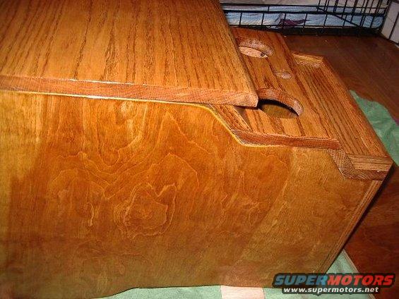 wooden center console with cup holders and a hinged lid