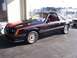 2002 Ford Mustang - This black 1985 Ford Mustang coupe features distinctive red racing stripes and a prominent 5.0 badge, indicating its powerful engine.