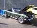 2002 Ford Mustang - Green 1965 Ford Mustang convertible parked outdoors with hood open, another car visible behind it.