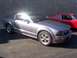 2002 Ford Mustang - A silver Ford Mustang GT is parked in front of a red classic car, with a Supermotors.net logo visible at the bottom right.