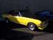 2002 Ford Mustang - A yellow and black 1967 Ford Mustang coupe is parked next to a blue car.